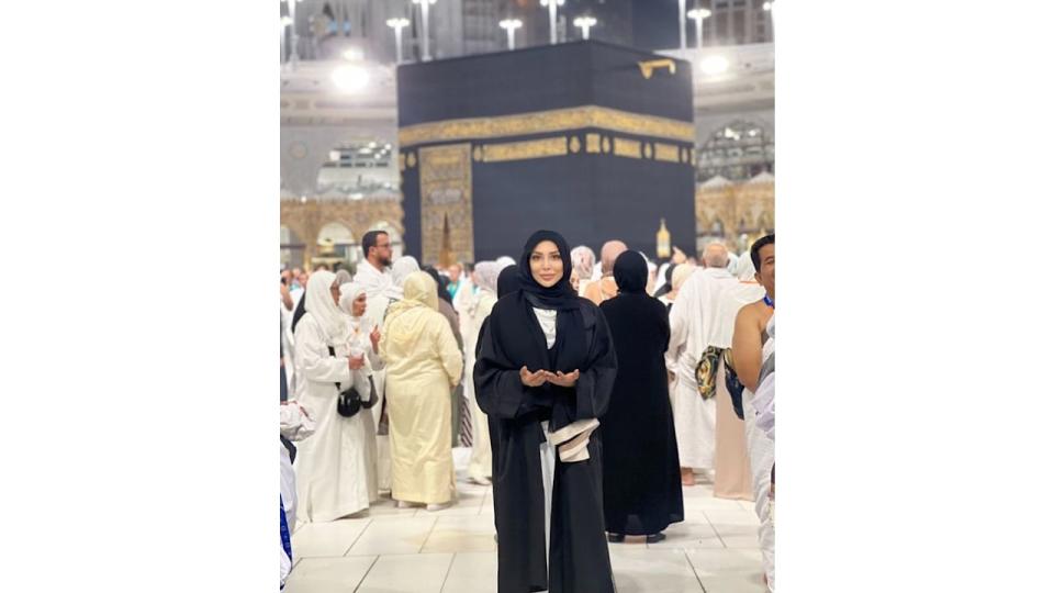 Farah El Kadhi in a black hijab in front of Mecca