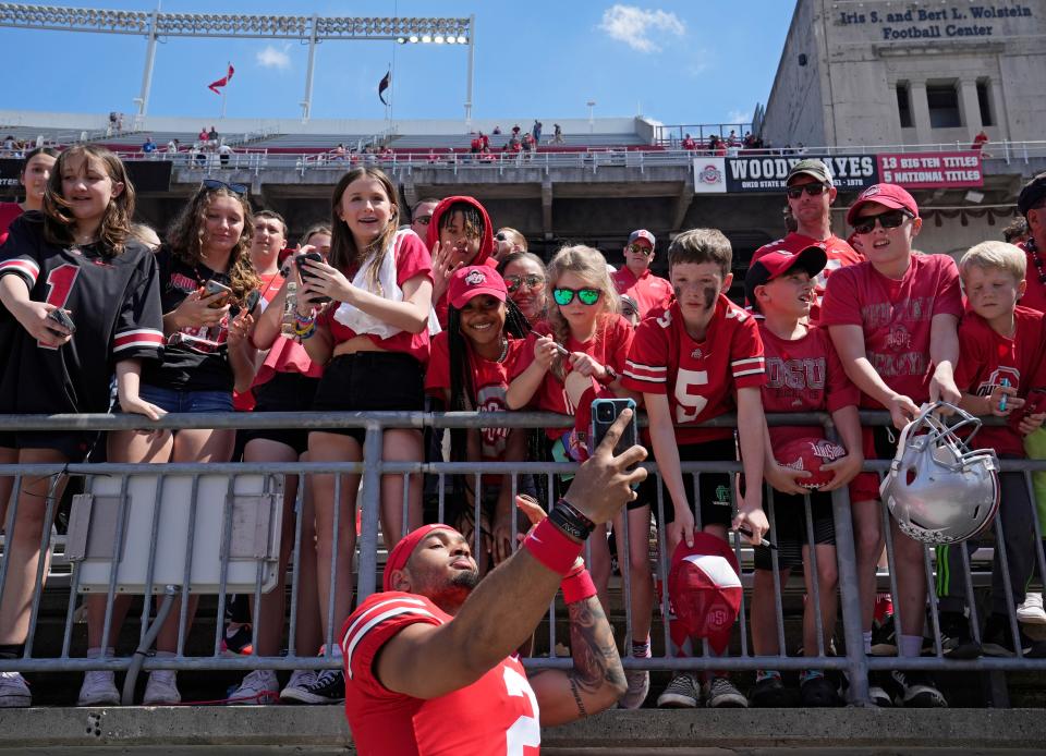 April 15, 2023; Columbus, Ohio, USA;  Wide receiver Emeka Egkuba (2) poses for photos with fans following the Ohio State spring football game Saturday at Ohio Stadium.Mandatory Credit: Barbara J. Perenic/Columbus Dispatch