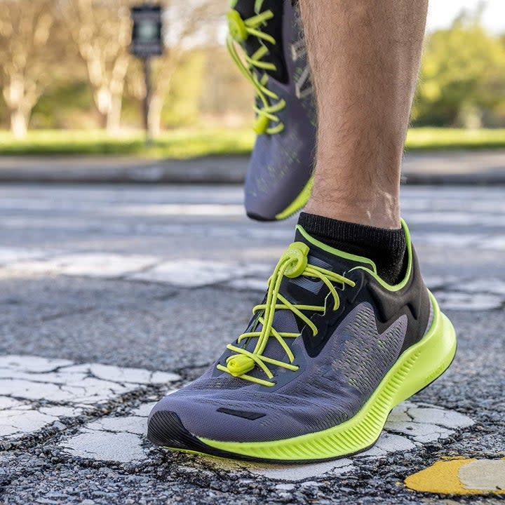 model wearing sneakers with bright green laces