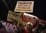 Demonstrators shout slogans during a protest against the 2014 World Cup, in Sao Paulo May 15, 2014. Road blocks and marches hit Brazilian cities on Thursday as disparate groups criticized spending on the upcoming World Cup soccer tournament and sought to revive a call for better public services that swept the country last June. The signs (in red) read: "There will be no World Cup". REUTERS/Nacho Doce