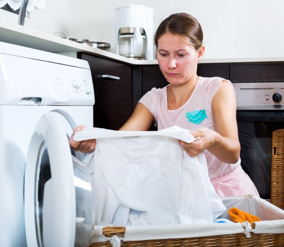 Woman inspecting a shirt she has pulled from the dryer