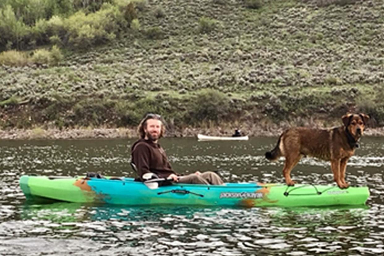 man and dog on a canoe