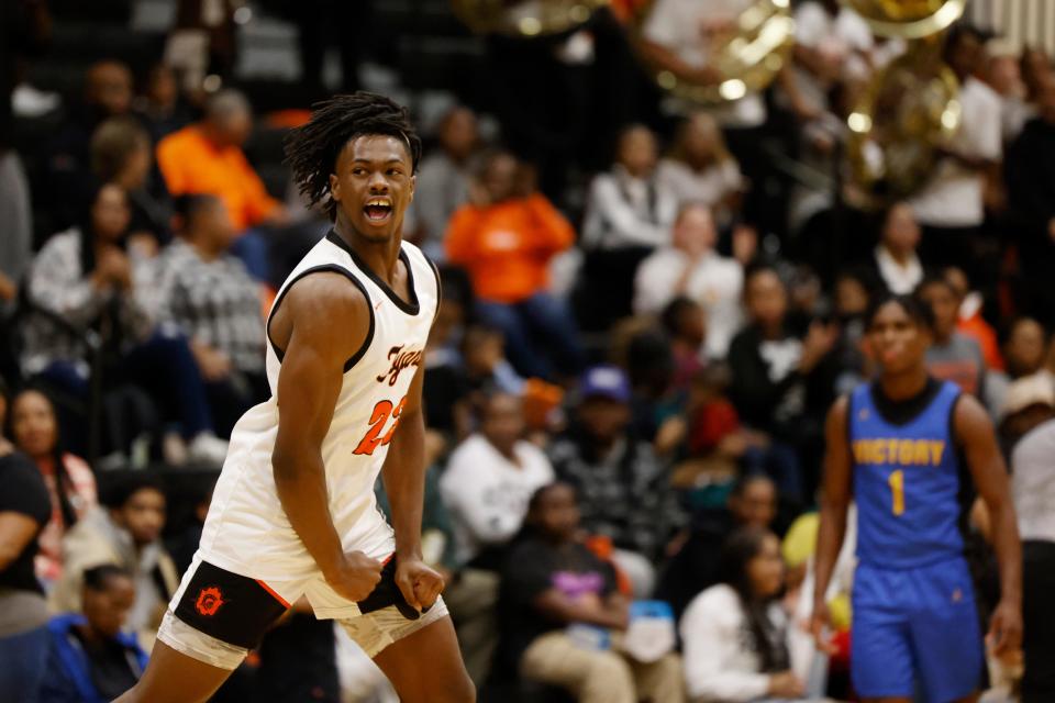 Douglass' Jaden Nickens reacts as Victory Christian's Michael Doctor looks on during the Trojans' 58-48 win Friday night.