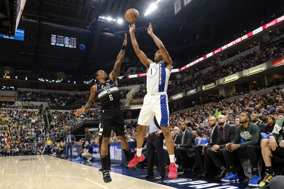 Indiana Pacers forward T.J. Warren (1) shots inn front of Milwaukee Bucks guard Eric Bledsoe (6) during the first half of an NBA basketball game in Indianapolis, Wednesday, Feb. 12, 2020. (AP Photo/AJ Mast)