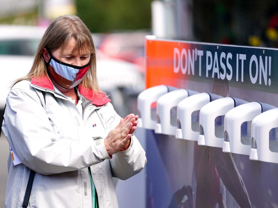 A Harlequins fan using the sanitiser provided outside the ground at Twickenham Stoop, London: PA