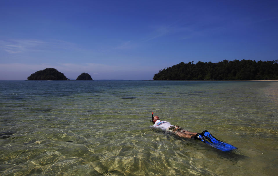 In this Feb. 10, 2014 photo, a U.S. tourist snorkels in the sea near Lampi Marine National Park on Lampi Island, Myanmar. Inaugurated in 1996, Lampi fit squarely into the paper park category until possibly last year, when six rangers from the Forestry Department were finally assigned to protect this 79-square- mile (204-square-kilometer) marine gem. It had been, and still largely remains, a do-as-you-please place. (AP Photo/Altaf Qadri)