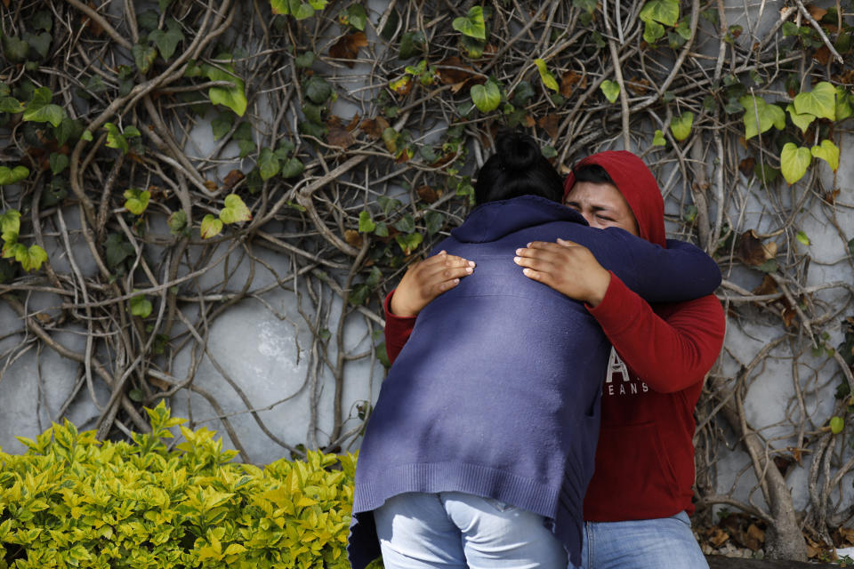 Relatives of Rosa Gomez embrace as they grieve after she was killed while commuting to work, when gunmen attacked Mexico City's police chief, in Mexico City, Friday, June 26, 2020. Heavily armed gunmen attacked and wounded Omar Garcia Harfuch in an operation that left several dead. (AP Photo/Rebecca Blackwell)