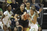 Oregon's Ruthy Hebard, left, Satou Sabally, rear, and Sabrina Ionescu, right, battle Stanford's Haley Jones for the ball during the first quarter of an NCAA college basketball game in Eugene, Ore., Thursday, Jan. 16, 2020. (AP Photo/Chris Pietsch)