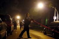 A Chicago police officer wraps up police tape at a crime scene where 7-year-old Amari Brown was shot and killed in Chicago, Illinois, United States, July 5, 2015. REUTERS/Jim Young