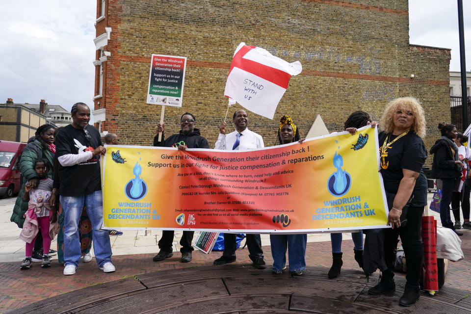 Anthony Brown, director of the Windrush Defenders C.I.C. marches holding an England's flag, as he takes part in the annual Afrikan Emancipation Day Reparations march, in Brixton, London, Sunday, Aug. 1, 2021. Black people whose right to live in the U.K. was illegally challenged by the government marked the anniversary Sunday of the act that freed slaves throughout the British Empire, drawing a direct link between slavery and the discrimination they suffered. Dozens of campaigners gathered in Brixton, a center of the Black community in south London, to back the international drive for reparations for the descendants of enslaved Africans and demand legislation to compensate legal residents who were threatened with deportation in what is known as the Windrush Scandal. (AP Photo/Alberto Pezzali)