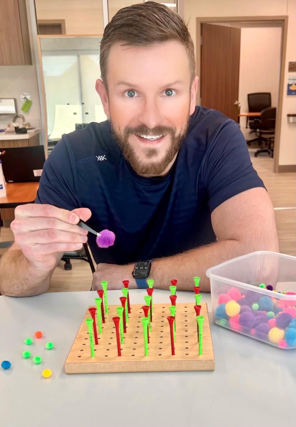 Joseph Poduslo works with a golf tee pegboard and tweezers to increase his fine motor control at a therapy session in Texas. Poduslo is recovering from a traumatic brain injury.