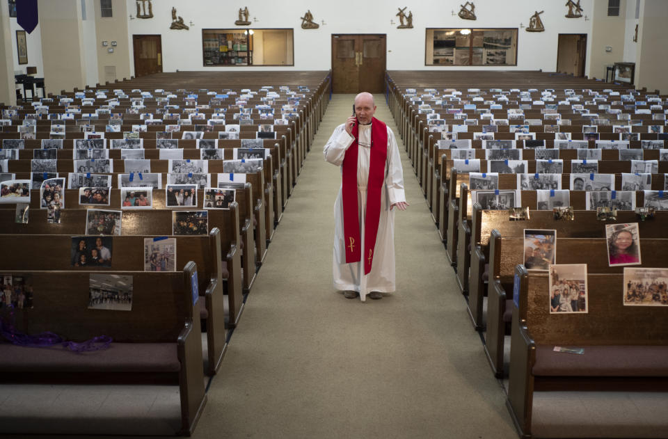 FILE - In this April 10, 2020, file photo, Rev. Nicolas Sanchez takes a phone call from a parishioner after live-streaming the Good Friday Mass without parishioners due to COVID-19 at St. Patrick's Catholic Church in Los Angeles. Now, in early May 2021, California has the lowest case rate in the country. (AP Photo/Damian Dovarganes, File)