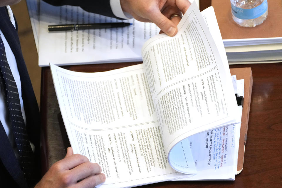 Solicitor General Scott G. Stewart reviews a printout of the Mississippi Constitution during debate on the constitutionality of a Mississippi law that would authorize some judges who would be appointed in a state where most judges are elected, Thursday, July 6, 2023, in Jackson, Miss. (AP Photo/Rogelio V. Solis)