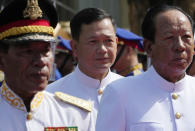 Tea Banh, right, Deputy Prime Minister and Defense Minister, walks together with Hun Manet, center, designate prime minister and son of Cambodia Prime Minister Hun Sen, also army chief, stands during a photo session in front of the National Assembly in Phnom Penh, Cambodia, Monday, Aug. 21, 2023.