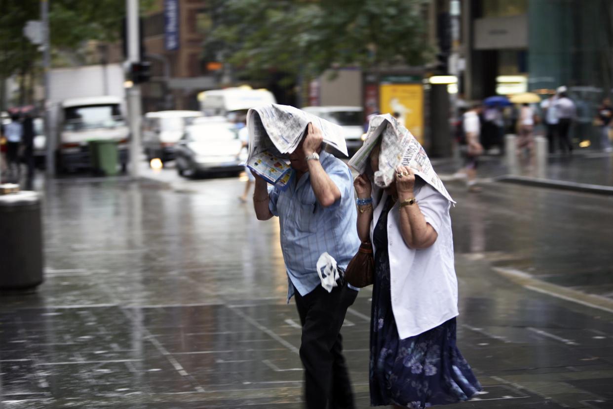 Couple getting drenched in rain in the city