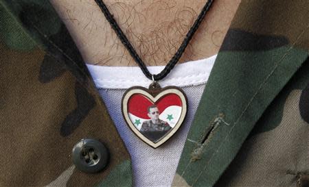 A soldier wears a picture of Syrian President Bashar al-Assad on his chest at Al-Hamidieh market in old Damascus, September 8, 2013. REUTERS/Khaled al-Hariri