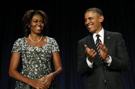 U.S. President Barack Obama applauds as he and First Lady Michelle Obama attend the National Prayer Breakfast in Washington February 6, 2014. REUTERS/Kevin Lamarque