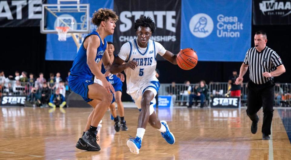 Curtis’ Zoom Diallo pushes the ball up court against Federal Way defender Isaiah Afework during their state semifinal game at the WIAA state basketball tournament in the Tacoma Dome in Tacoma, Washington, on Friday, March 3, 2023. Curtis won the game, 56-43.