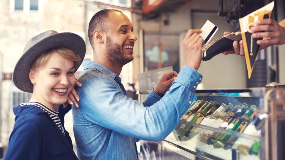 Young man doing contactless payment for fries.