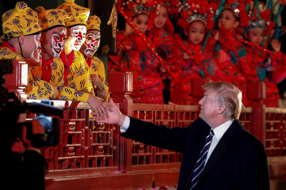 President Donald Trump shakes hands with opera performers at the Forbidden City.&nbsp;