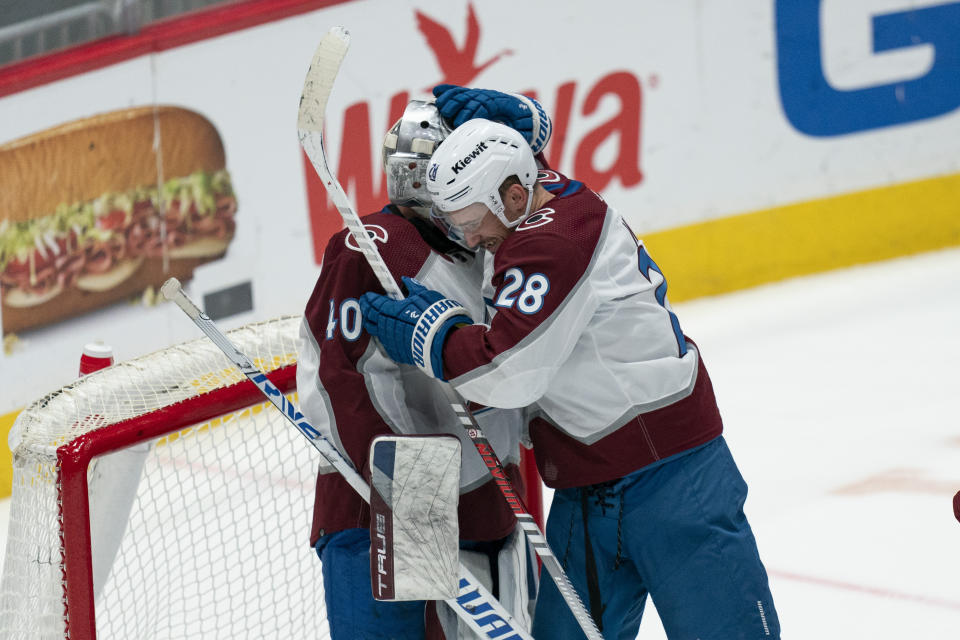 Colorado Avalanche goaltender Alexandar Georgiev (40) and Avalanche left wing Miles Wood (28) celebrate their team's victory over the Washington Capitals after an NHL hockey game, Tuesday, Feb. 13, 2024, in Washington. (AP Photo/Stephanie Scarbrough)