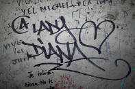 <p>Graffitis are pictured near the makeshift monument for the late Princess Diana above the Pont de l’Alma tunnel in Paris, Aug. 31, 2017. (Photo: Kamil Zihnioglu/AP) </p>