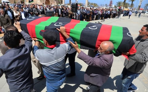 People carry a flag draped coffin of a victim of an overnight shelling, during a funeral at Martyrs' Square in Tripoli - Credit: &nbsp;HANI AMARA/Reuters