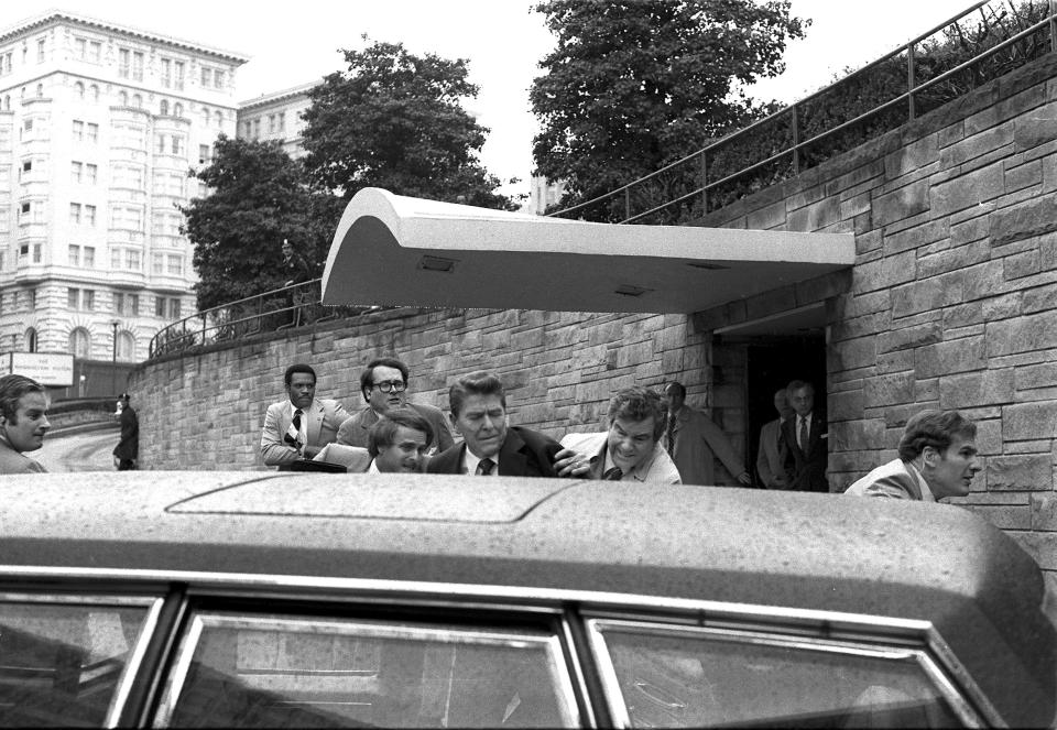 FILE - President Ronald Reagan is shoved into the President's limousine by secret service agents after being shot outside a Washington hotel, March 30, 1981. Secret service agent Jerry Parr, in a raincoat to the right of Reagan, who pushed Reagan into the limousine, was credited with saving Reagan's life on the day he was shot. (AP Photo/Ron Edmonds, File)