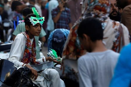 A boy waits for customers as he sells patriotic memorabilia, ahead of Pakistan's Independence Day, along a market in Karachi