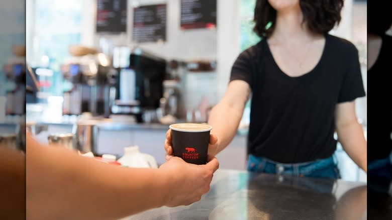 barista handing coffee over