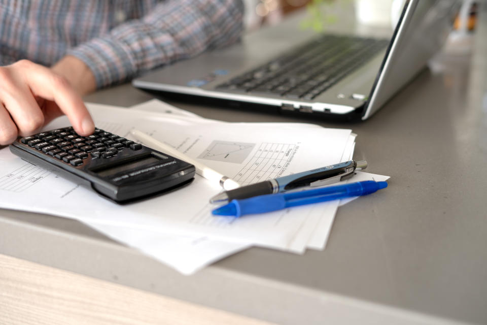 Anonymous man uses calculator while doing homework