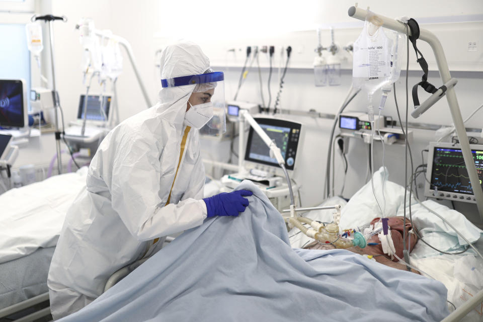 A member of the medical staff attends to a patient at the COVID-19 ICU unit of the Dr. Abdulah Nakas General Hospital in Sarajevo, Bosnia, Friday, Sept. 24, 2021. The COVID-19 rate of infections in Bosnia, a country where only about 12% of the population is fully vaccinated against COVID-19, is on a rising trend over the past weeks. (AP Photo)