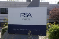 The logo of French car maker maker PSA is seen outside a technical center Tuesday, May 26, 2020 in Villacoublay, west of Paris. French President Emmanuel Macron is set to unveil on Tuesday new measures to rescue the country's car industry, which has been hammered by the virus lockdown and the resulting recession. The issue is politically sensitive, since France is proud of its auto industry, which employs 400,000 people in the country and is a big part of its manufacturing sector. (AP Photo/Michel Euler)