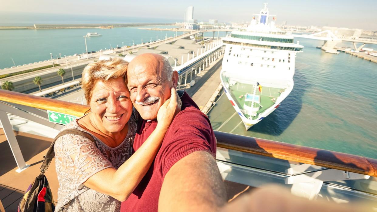 Senior happy couple taking selfie on ship on harbor background - Mediterranean cruise travel tour - Active elderly concept with retired people around the world - Bright sunny afternoon color tones.