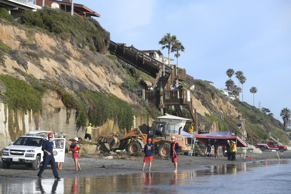 Search and rescue personnel work at the site of a cliff collapse at a popular beach Friday, Aug. 2, 2019, in Encinitas, Calif. At least one person was reportedly killed, and multiple people were injured, when an oceanfront bluff collapsed Friday at Grandview Beach in the Leucadia area of Encinitas, authorities said.(AP Photo/Denis Poroy)