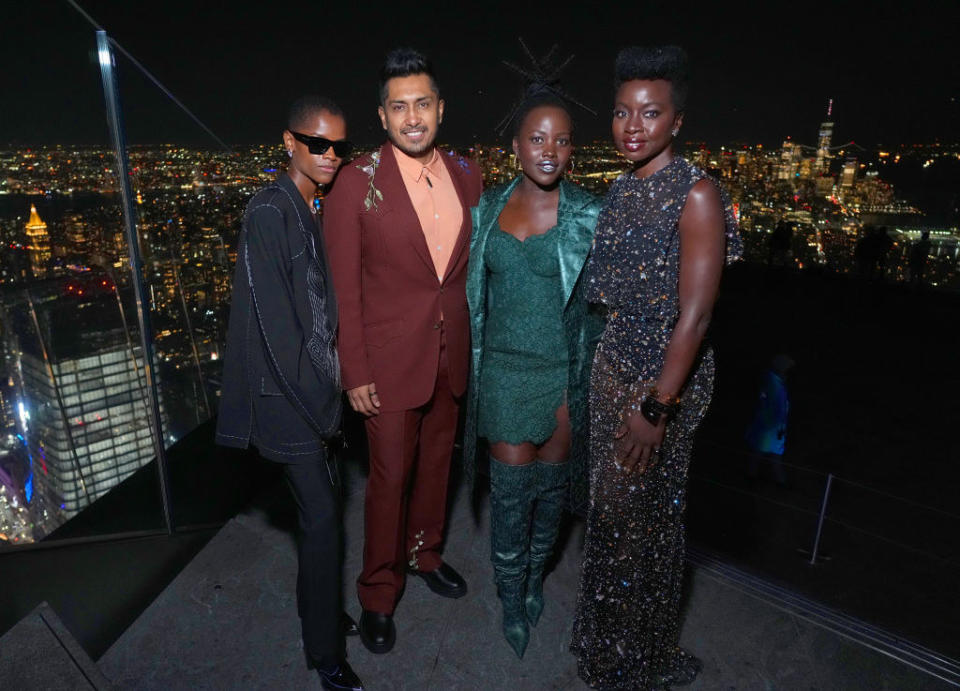 Letitia, Tenoch, Lupita, and Danai standing together on a roof with the Manhattan  nighttime skyline in the background