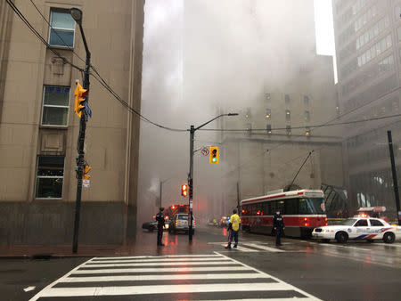 Smoke rises as police block off an intersection in the financial district after reports of a loud blast and heavy smoke could be seen in Toronto, Ontario, Canada May 1, 2017. REUTERS/Anna Mehler Paperny