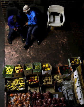 Vendors chat as they wait for customers at Jeppestown men's hostel in Johannesburg May 19, 2015. REUTERS/Siphiwe Sibeko