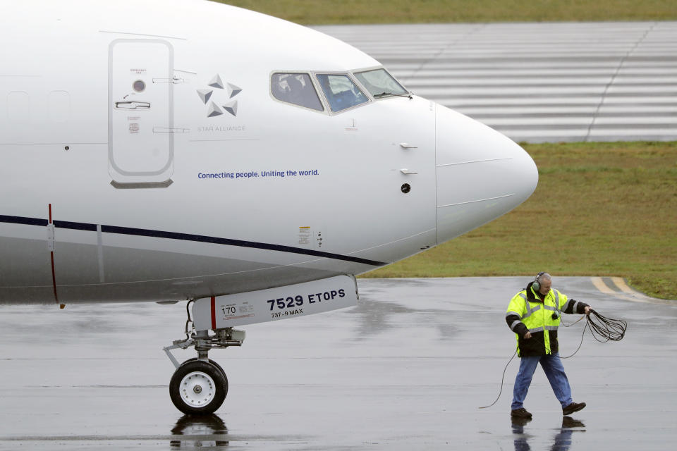 FILE - A worker coils up the cord for a flight deck communications headset as a United Airlines Boeing 737 Max airplane prepares to take off, Wednesday, Dec. 11, 2019, at Renton Municipal Airport in Renton, Wash. Federal safety regulators are warning airlines to make sure that workers stay away from jet engines that are still running. The Federal Aviation Administration said Friday, Aug. 25, 2023, that the alert follows “multiple" incidents of workers being hurt or killed during ground operations. (AP Photo/Ted S. Warren, File)