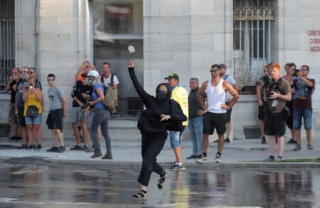 A demonstrator throws an object at the police at a protest during the G7 summit, in Bayonne