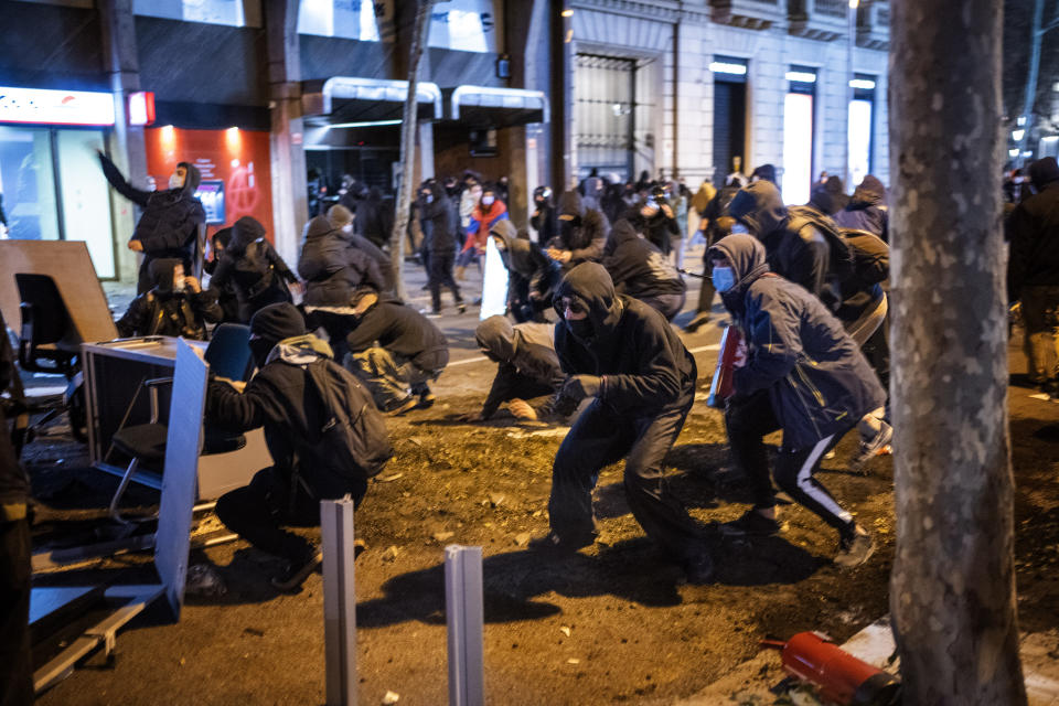 Demonstrators clash with police after a protest condemning the arrest of rap singer Pablo Hasél in Barcelona, Spain, Tuesday, Feb. 16, 2021. Violent street protests have erupted in some Spanish cities after police arrested a rapper who resisted imprisonment and has portrayed his case as a fight for free speech. (AP Photo/Emilio Morenatti)