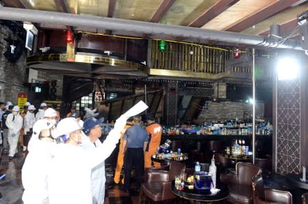 South Korean firefighters and officials examine a collapsed structure of a nightclub in Gwangju