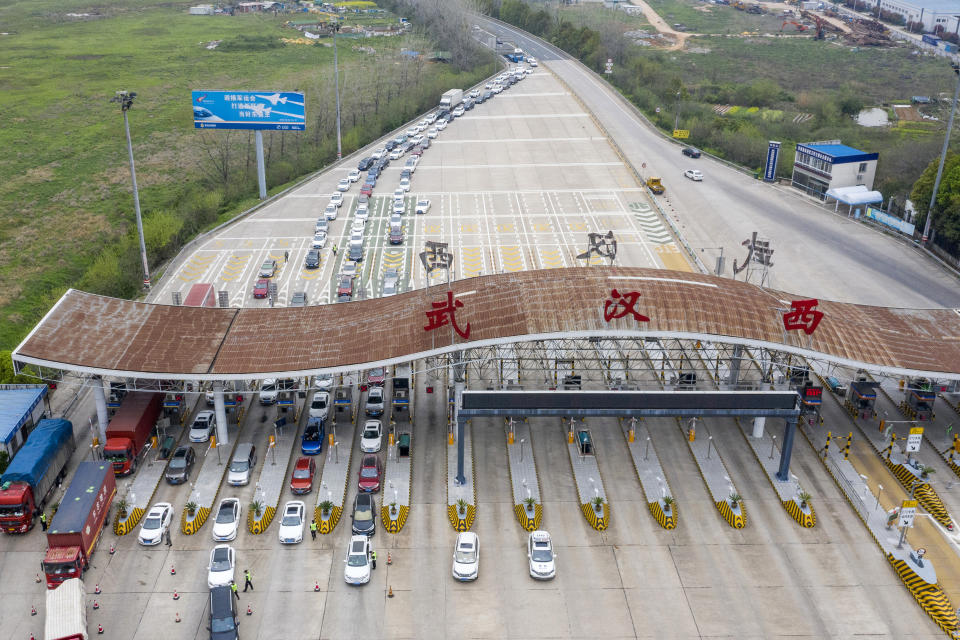 In this March 24, 2020, photo released by Xinhua News Agency, an aerial photo shows vehicles waiting to cross into Wuhan at a highway toll station in Wuhan, in central China's Hubei Province. Hubei has ended a lockdown for most of the province, allowing people who have passed health checks to leave for the first time in two months. The provincial capital of Wuhan, where the virus hit hardest, remains locked down until April 8. (Cai Yang/Xinhua via AP)