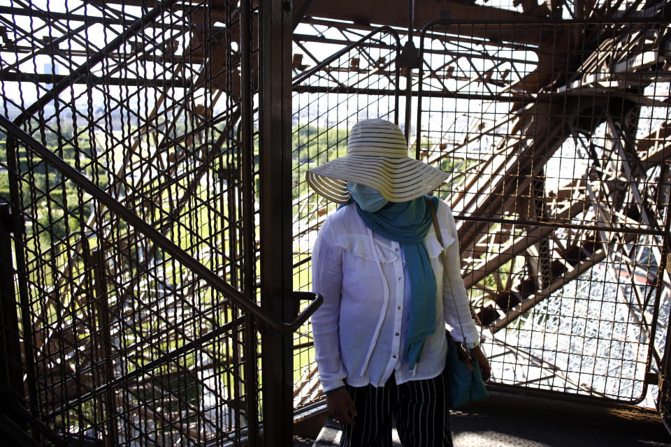 A visitor climbs the stairs of the Eiffel Tower, in Paris, Thursday, June 25, 2020. The Eiffel Tower reopens after the coronavirus pandemic led to the iconic Paris landmark's longest closure since World War II. (AP Photo/Thibault Camus)