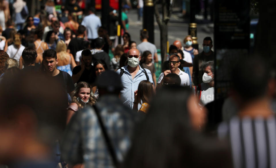 A man wearing a face mask is pictured among a crowd in Oxford Street, following the coronavirus disease (COVID-19) outbreak, in London, Britain, July 18, 2020. REUTERS/Simon Dawson