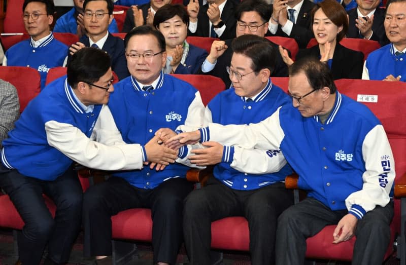 Officials of the main opposition Democratic Party, including its leader Lee Jae-myung (2nd from R, front row), react at the National Assembly, as TV exit polls of the general elections to choose 300 lawmakers project its overwhelming victory over the ruling People Power Party. -/YNA-Pool/dpa