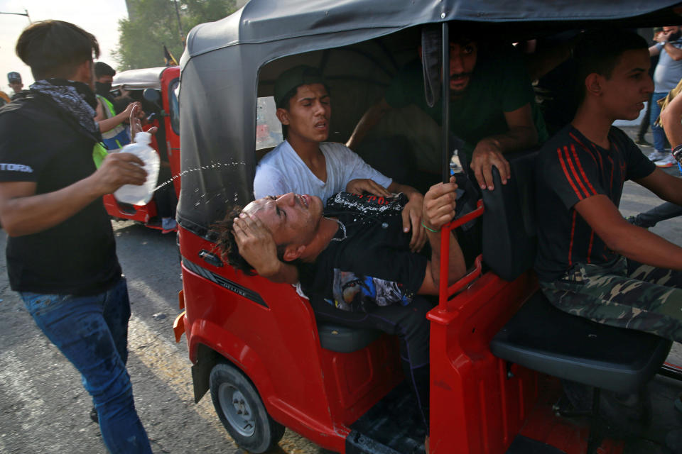 An injured protester is rushed to a hospital during clashes between security forces and anti-government protesters on the closed Joumhouriya Bridge that leads to the Green Zone government areas, in Baghdad, Iraq, Sunday, Oct. 25, 2020. Thousands of Iraqi protesters have taken to the streets to mark one year since mass anti-government demonstrations swept Baghdad and Iraq's south. Protesters marched Sunday in the capital and several southern cities to renew demands to bring an end to corruption perpetuated by Iraq's politicians. (AP Photo/Khalid Mohammed)