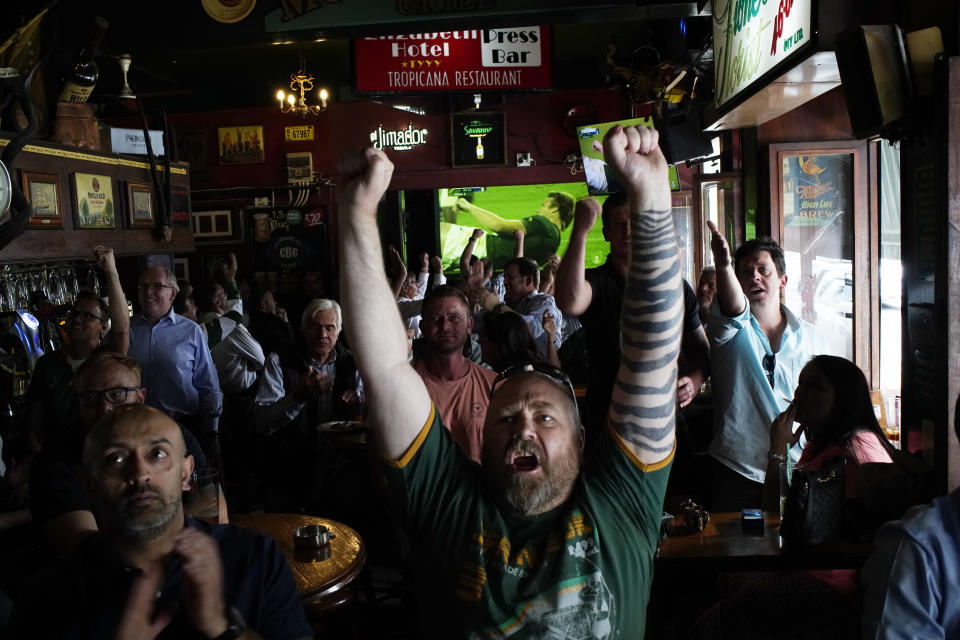 South African fans react to their team scoring as they watch in Johannesburg, South Africa Friday Oct. 4, 2019 in a local pub the Rugby World Cup Pool B game between South Africa and Italy being played in Japan South Africa defeated Italy 49-3. (AP Photo/Jerome Delay)