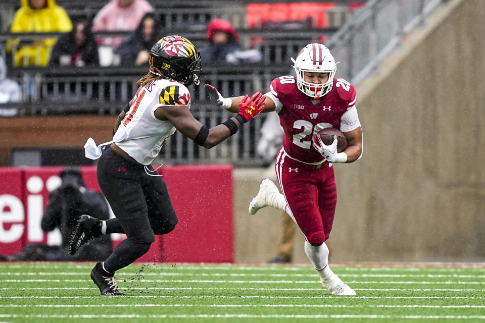 Wisconsin running back Isaac Guerendo (20) runs against Maryland linebacker Gereme Spraggins (21) during the first half of an NCAA college football game Saturday, Nov. 5, 2022, in Madison, Wis. (AP Photo/Andy Manis)