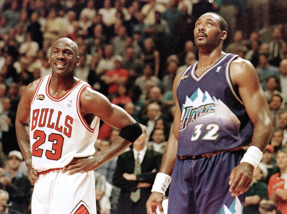 Michael Jordan (L) of the Chicago Bulls smiles while standing next to Karl Malone of the Utah Jazz 07 June in the first half of game three of the NBA Finals at the United Center in Chicago, IL. The seven game series is tied at 1-1.        AFP PHOTO    Jeff HAYNES (Photo by JEFF HAYNES / AFP) (Photo by JEFF HAYNES/AFP via Getty Images)